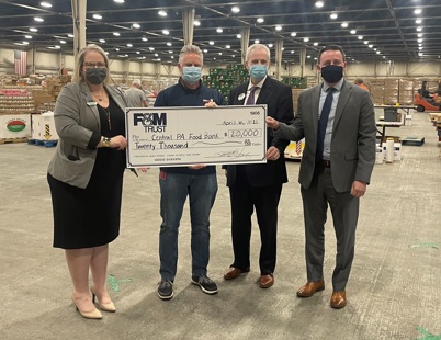 photo of bank and food bank representatives holding large vanity check